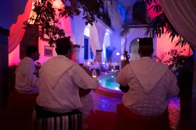 a group of men standing in front of a pool at Riad Dar Alfarah in Marrakech