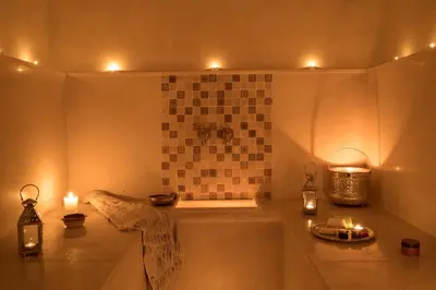 a small bathroom with candles in a bath tub at Riad Dar Alfarah in Marrakech