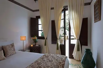 a bedroom with a bed and a large window at Riad Dar Alfarah in Marrakech