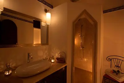 a bathroom with a sink and a mirror and a shower at Riad Dar Alfarah in Marrakech