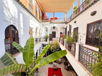 an indoor courtyard of a building with plants at Riad Aya in Marrakech