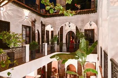 a staircase in a building with a woman in the background at Riad Aya in Marrakech