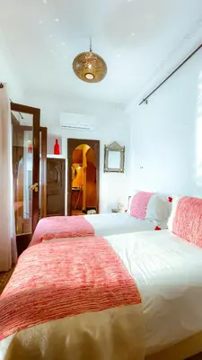 a bedroom with a large bed with red sheets at Riad Aya in Marrakech