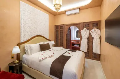 a bedroom with a bed and a mirror and a television at Riad Mabrouk in Marrakech