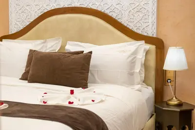a bed with white sheets and pillows on it at Riad Mabrouk in Marrakech
