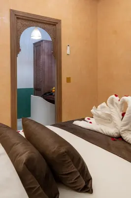 a hotel room with a bed with a mirror at Riad Mabrouk in Marrakech