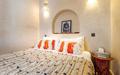 a bedroom with a bed with orange and white pillows at Dar Picolina in Marrakech