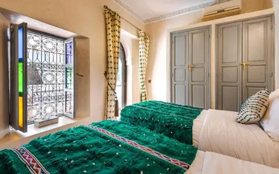 a bedroom with a green bed and a window at Dar Picolina in Marrakech