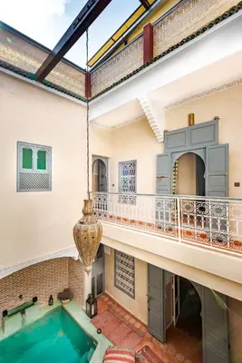 an indoor pool in a house with a balcony at Dar Picolina in Marrakech