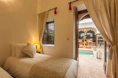 a bedroom with a bed and a view of a pool at Riad Amin in Marrakech