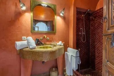 a bathroom with a sink and a shower with a mirror at Riad Amin in Marrakech