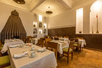 a dining room with white tables and chairs at Riad Amin in Marrakech