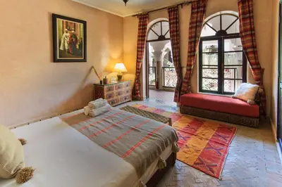 a bedroom with a bed and a red couch at Riad Nabila in Marrakech