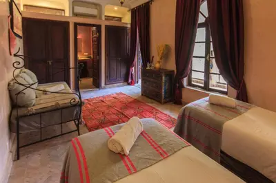 a bedroom with two beds and a window at Riad Nabila in Marrakech