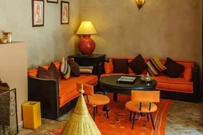 a living room with an orange couch and a table at Riad Nabila in Marrakech