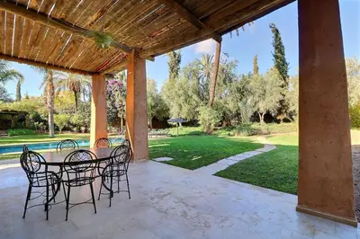 a patio with chairs and a table and a pool at Villa de Luxe Domaine des Kasbahs in Marrakech