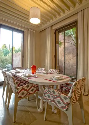 a dining room with a white table and chairs at Villa de Luxe Domaine des Kasbahs in Marrakech