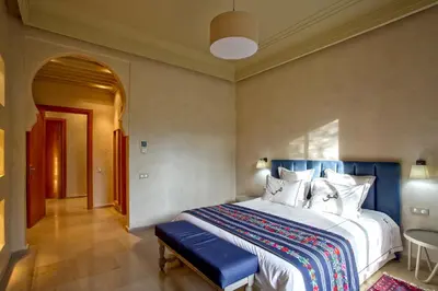 a bedroom with a large bed with a blue headboard at Villa de Luxe Domaine des Kasbahs in Marrakech
