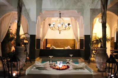 a table in a room with a chandelier at Riad Pachavana in Marrakech
