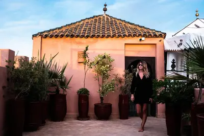 a woman in a black dress standing in front of a building at Riad Pachavana in Marrakech
