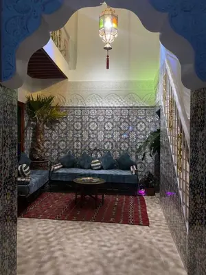 a living room with a blue couch and a table at Dar Dikrayat in Marrakech