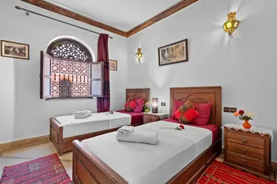 a bedroom with two beds and a window at Riad Marwa Marrakech in Marrakech