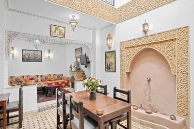 a living room with a table and a fireplace at Riad Marwa Marrakech in Marrakech