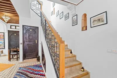 a staircase in a home with a wooden door at Riad Marwa Marrakech in Marrakech