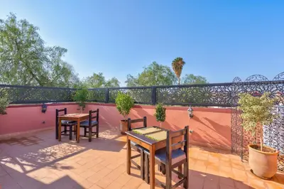 a patio with two tables and chairs on a balcony at Riad Marwa Marrakech in Marrakech