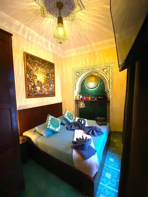 a bedroom with two beds with blue pillows at Riad La Perle Rouge in Marrakech