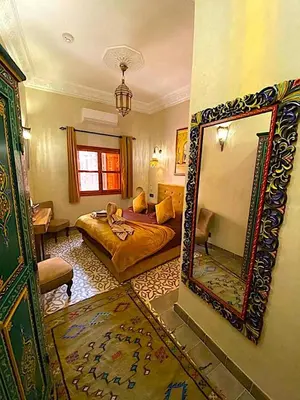 a bedroom with a bed and a large mirror at Riad La Perle Rouge in Marrakech
