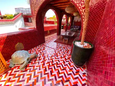 a red tile floor with a man sitting on the floor at Riad La Perle Rouge in Marrakech