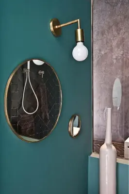 a mirror on a blue wall with a vase and a lamp at Numa Marrakech in Marrakech