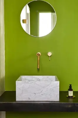 a green bathroom with a sink and a mirror at Numa Marrakech in Marrakech