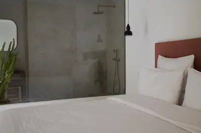 a bedroom with a white bed and a shower at Numa Marrakech in Marrakech