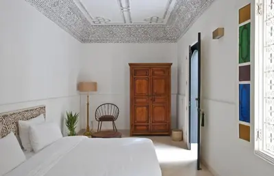 a bedroom with a bed and a wooden cabinet at Numa Marrakech in Marrakech