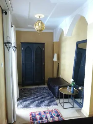 a living room with a bed and a table at Riad AZZA in Marrakech