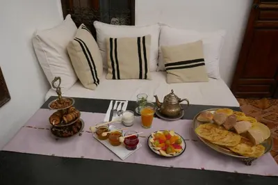 a breakfast table with food and drinks on a bed at Riad AZZA in Marrakech