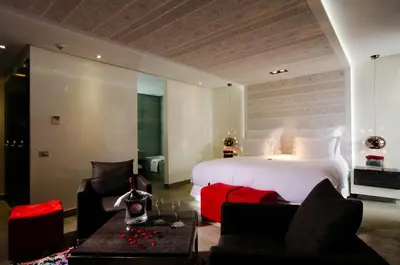 a bedroom with a large white bed and some chairs at Cesar Resort & Spa in Marrakech