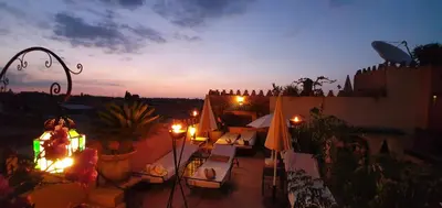 a patio with chairs and umbrellas at night at Abelia Riad - 2025 Guest Choice Award in Marrakech