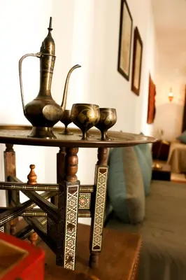 a table with a tea kettle and two cups on it at Riad Bellamane Marrakech in Marrakech