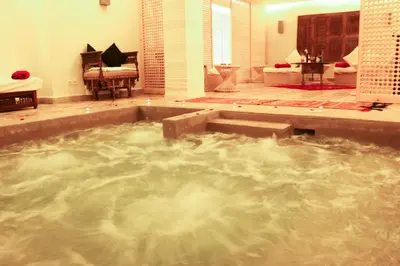 a large bath tub filled with water in a bathroom at Riad Bellamane Marrakech in Marrakech