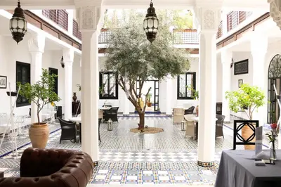 a courtyard with a tree in the middle of a building at Riad Bellamane Marrakech in Marrakech