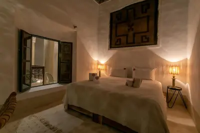 a bedroom with a bed with two lamps and a window at Riad Safar in Marrakech
