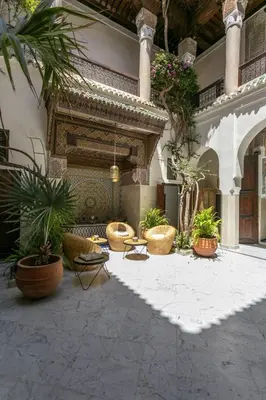 a courtyard with potted plants and a fireplace at Riad Safar in Marrakech