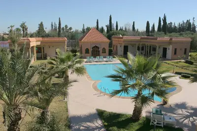 an aerial view of a house with a swimming pool and palm trees at Villa Zahra Palmeraie in Marrakech