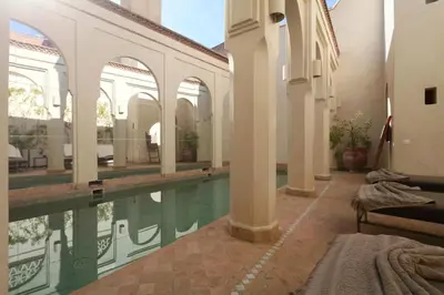 a swimming pool in a building with a house at La Villa Nomade in Marrakech