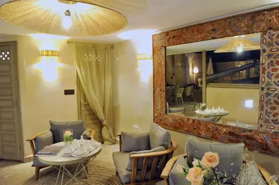 a living room with a table and a mirror at Riad Anjar in Marrakech