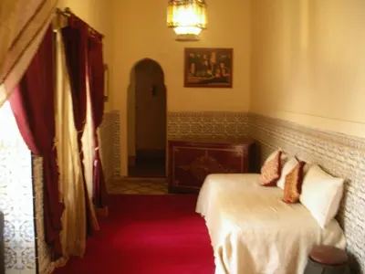 a bedroom with a bed and a chandelier at Riad El Filali in Marrakech