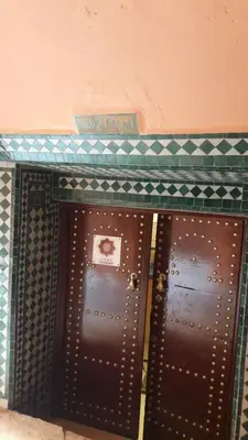 two brown doors in a room with a wall at Riad El Filali in Marrakech